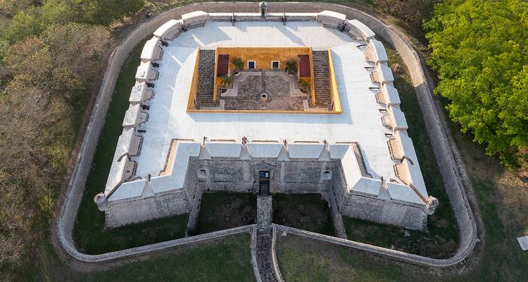 Aerial view of star-shaped 18th-century fort surrounded by green trees