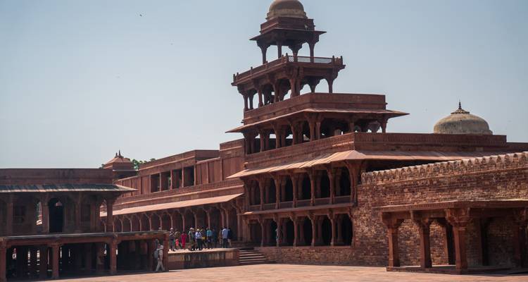 Das fünfstöckige Panch Mahal und die umgebenden Mogul-Gebäude unter klarem Himmel mit Touristen darunter.