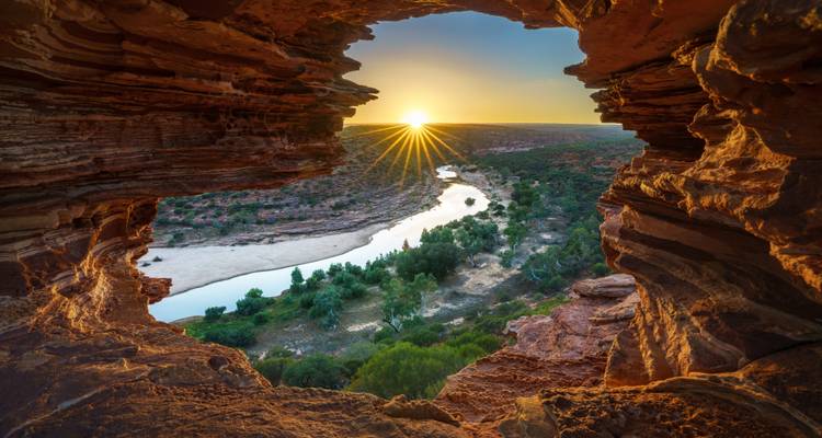 Dramatic sunrise through Nature’s Window rock arch overlooking a winding river and outback gorge at Kalbarri.