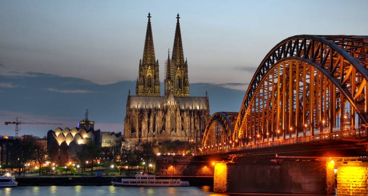 Twilight view of illuminated Hohenzollern Bridge and Cologne Cathedral over the Rhine