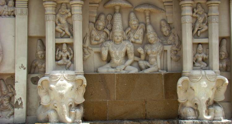 Intricate stone bas-relief of Hindu deities and elephants on a South Indian temple wall
