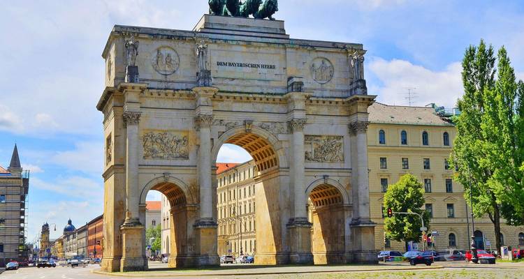 Drietalige Siegestor-monument staande op een brede Münchense laan onder helder daglicht.