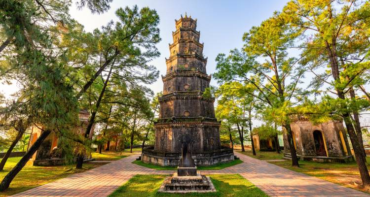 Die historische Thien Mu Pagode erhebt sich bei warmem Nachmittagslicht zwischen Kiefern.
