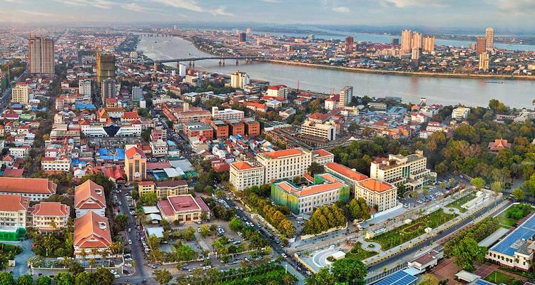 Aerial panorama of Phnom Penh with Tonlé Sap and Mekong rivers converging amid city skyline.