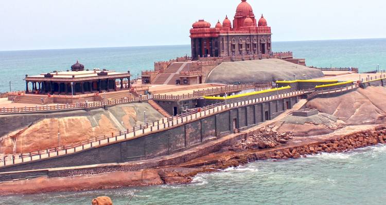 Zijkant van het Vivekananda Rock Memorial complex verbonden door loopbruggen over een turquoise zee.