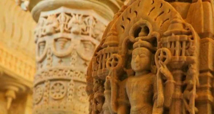 Detailed sandstone carving of a deity inside a richly decorated Jain temple.