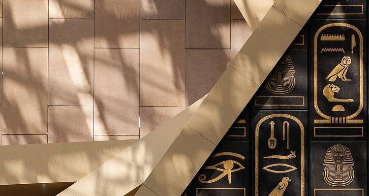 Abstract detail of museum wall casting patterned shadows beside gold hieroglyphic panels.
