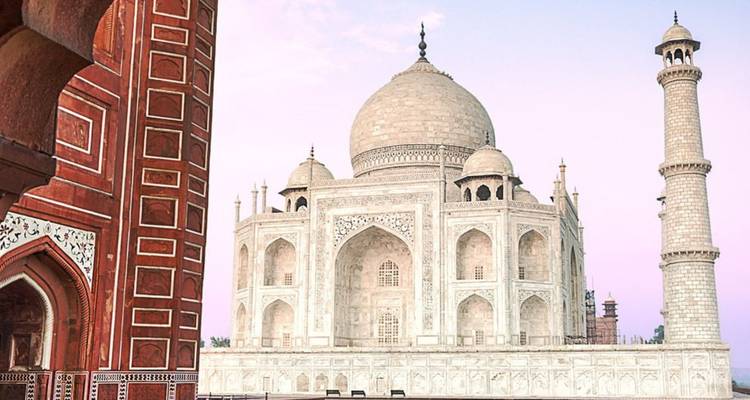 Das ikonische weiße Marmor-Taj Mahal glänzt sanft gegen einen pastellfarbenen Himmel in der Morgenröte