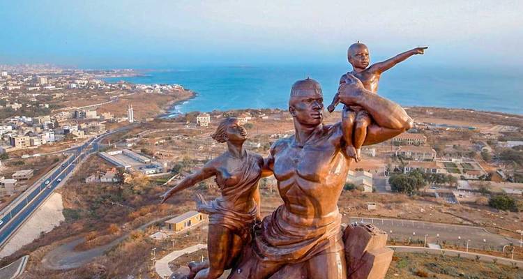 Massive bronze sculpture of a family overlooking a coastal city and the ocean