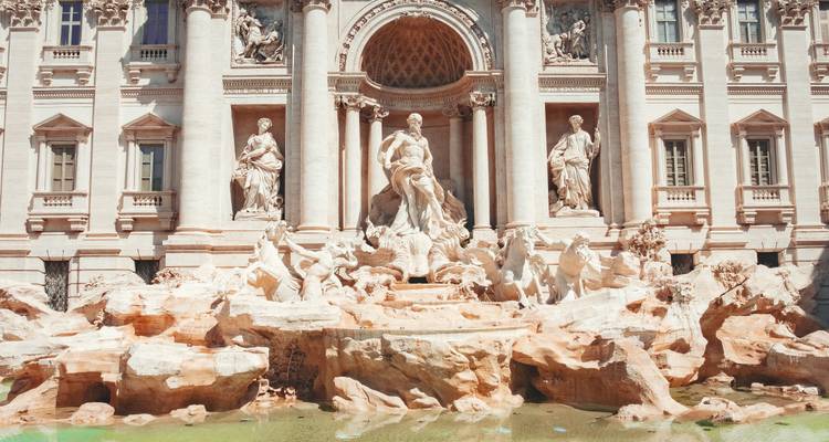 Vista frontal más cercana de las esculturas y cascadas de la Fontana de Trevi bajo una luz brillante.