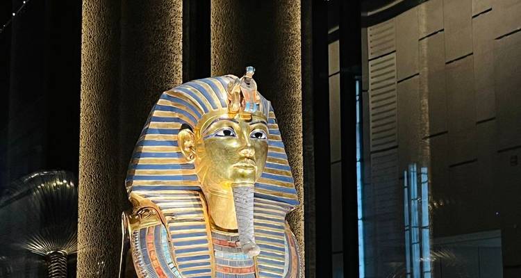 Masque funéraire doré de Toutankhamon exposé dans une galerie moderne.