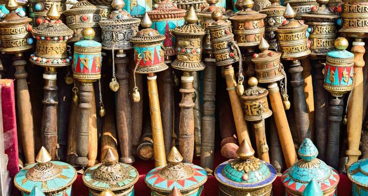 Close-up of ornate Tibetan prayer wheels and colourful hand-crafted spinners.