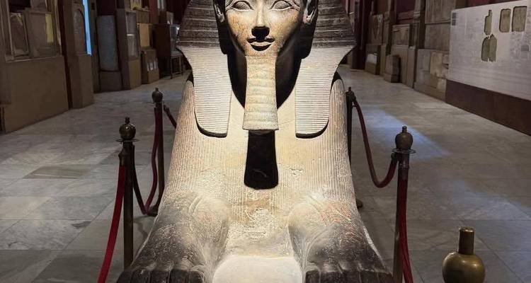Ancient sphinx statue on display inside a museum hall roped off from visitors