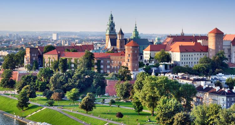 Historic Wawel Castle complex rises above the Vistula River and green parks of Krakow.