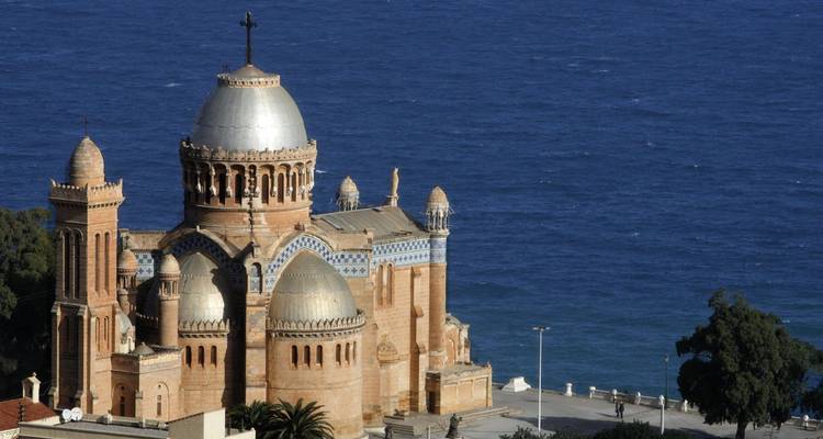 Elegante koepels van de Basilica van Notre-Dame d'Afrique die boven de Middellandse Zee uitsteken.