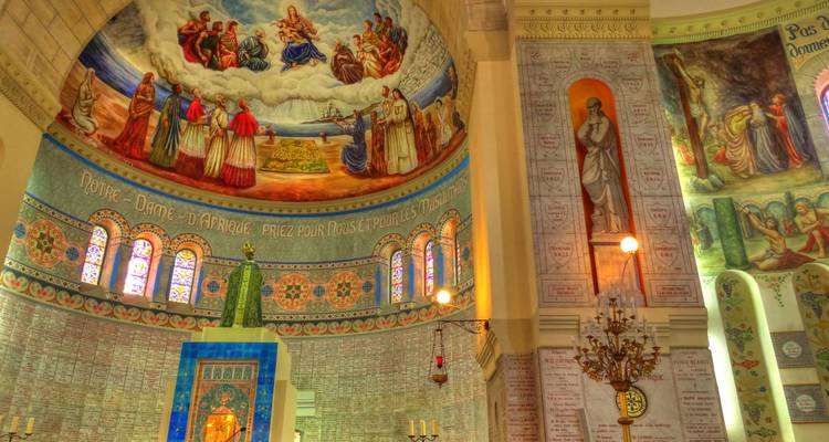 Levendige mozaïeken en fresco's versieren het koepelinterieur van een basiliek die wordt verlicht door warme lampen.
