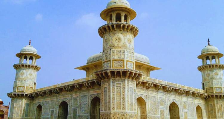 Das zart eingelegte weiße Marmor Itimad-ud-Daula Grabmal, bekannt als das Baby Taj, erhebt sich vor einem klaren Himmel.