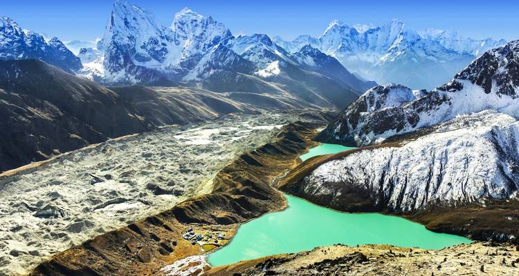 Turquoise glacial lakes sit below rugged snow-capped Himalayan peaks and moraine ridges.