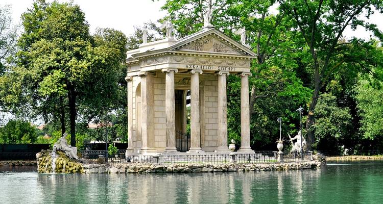 Temple of Aesculapius on an island in Rome’s Villa Borghese lake surrounded by lush greenery.