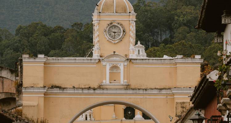 Close-up of the yellow Santa Catalina Arch with mountain backdrop in Antigua.