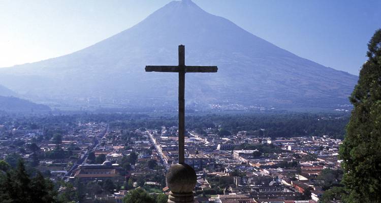 Stone cross overlooking Antigua city with Volcán de Agua rising in the background.
