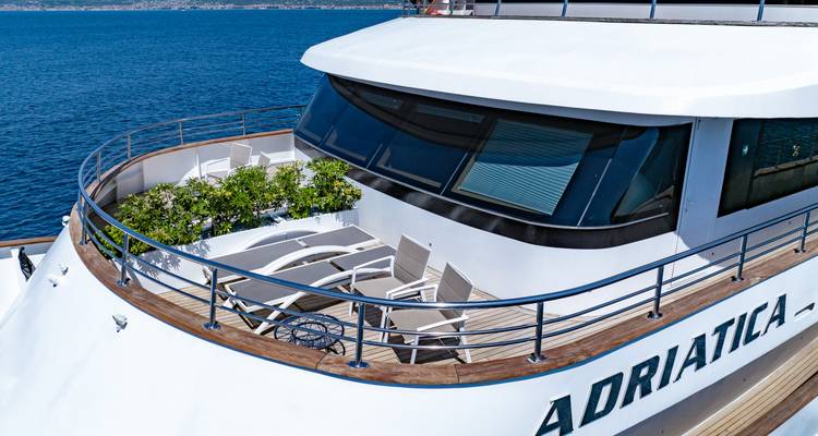 Close-up of the yacht's forward sun terrace with loungers overlooking the sea.