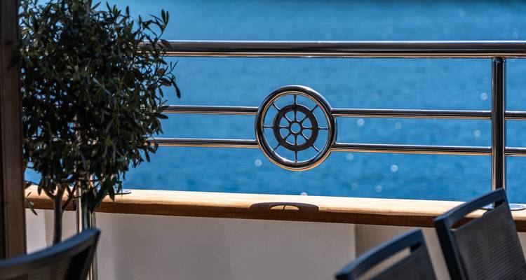 Decorative metal ship’s rail detail with sparkling sea backdrop.