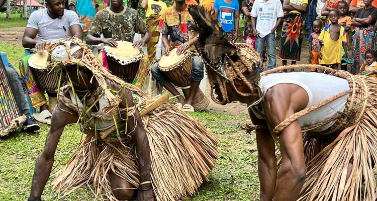Village celebration with drummers and dancers in straw attire.