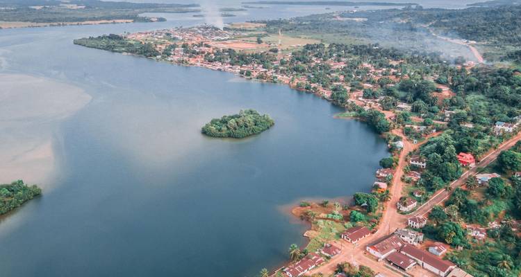 Aerial shot of a waterway town with a small forested island in the center.