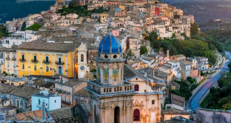 Twilight view over Ragusa Ibla’s terracotta rooftops dominated by the blue-tiled dome of San Giorgio