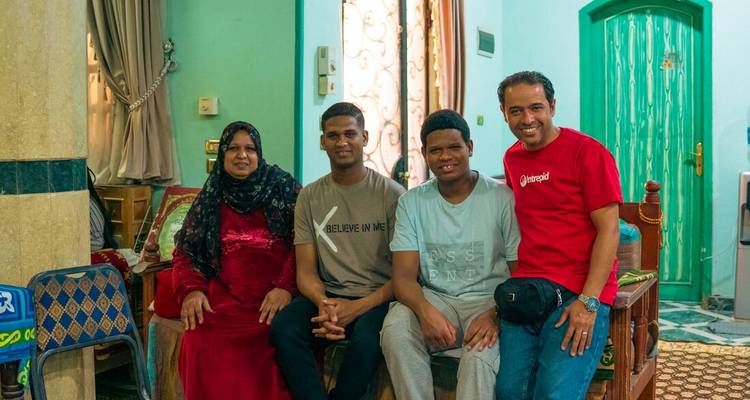 Local Egyptian family and guide posing for a friendly photo inside a colourful home.
