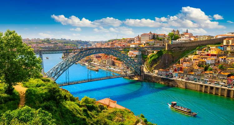 Vue panoramique du pont Dom Luís I enjambant le fleuve Douro avec les bâtiments colorés de Porto sur la colline.