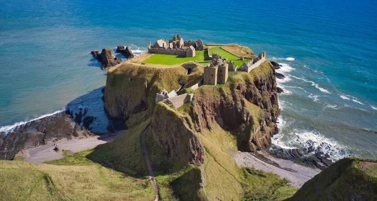 Spectacular aerial view of Dunnottar Castle perched on a rocky promontory surrounded by the North Sea