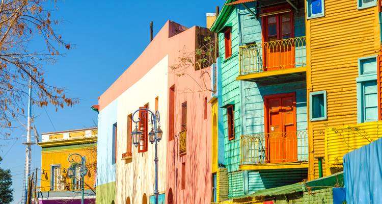 Die hell angestrichenen Fassaden der farbenfrohen Häuser von La Boca leuchten unter einem klaren blauen Himmel von Buenos Aires.