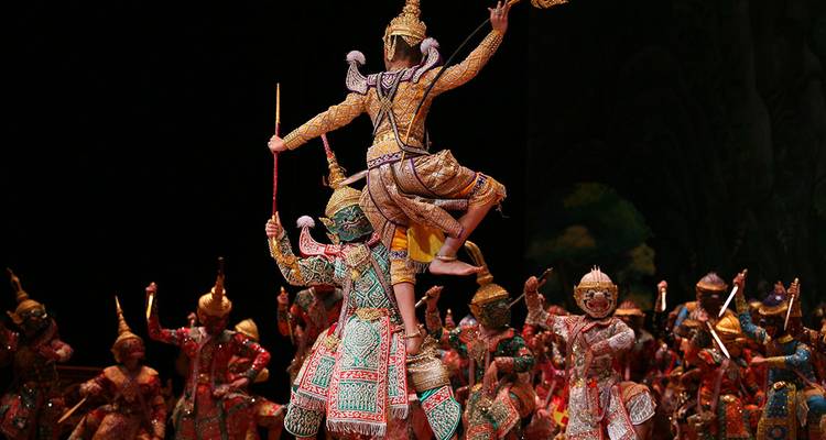 Lavish Thai Khon masked dance performance on stage with vibrantly costumed performers striking dramatic poses.