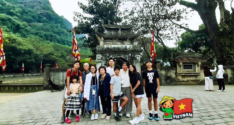 Family standing in front of an ancient stone gate with mountains in the background