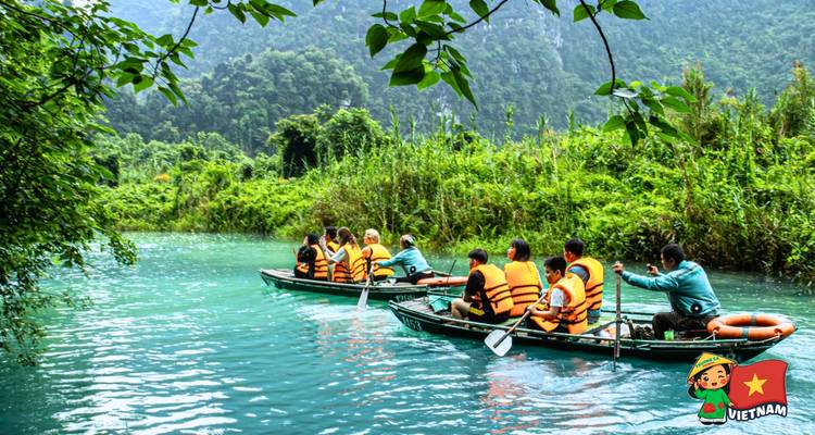 Tourists paddling through turquoise river in inflatable kayaks surrounded by lush jungle