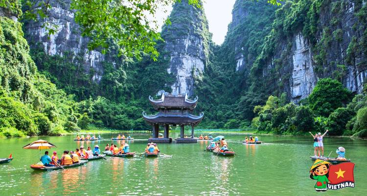 Scenic lake surrounded by towering limestone cliffs with dozens of tourist boats