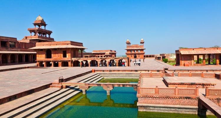 Patios abiertos, pabellones y una piscina ornamental de Fatehpur Sikri bañados por el brillante sol.