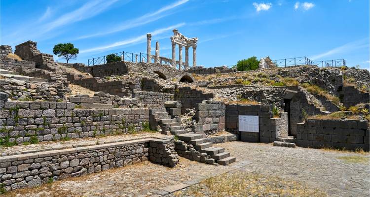 Ruines de l'Acropole de Pergame avec des colonnes de marbre debout sous un ciel bleu éclatant.