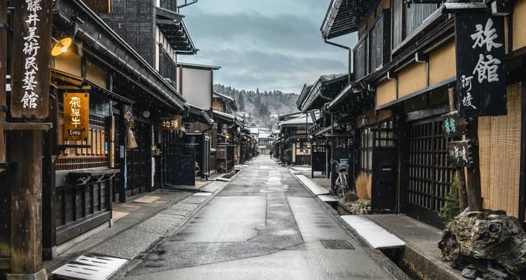 Snow-dusted traditional wooden street of Takayama’s old town on a quiet winter morning.