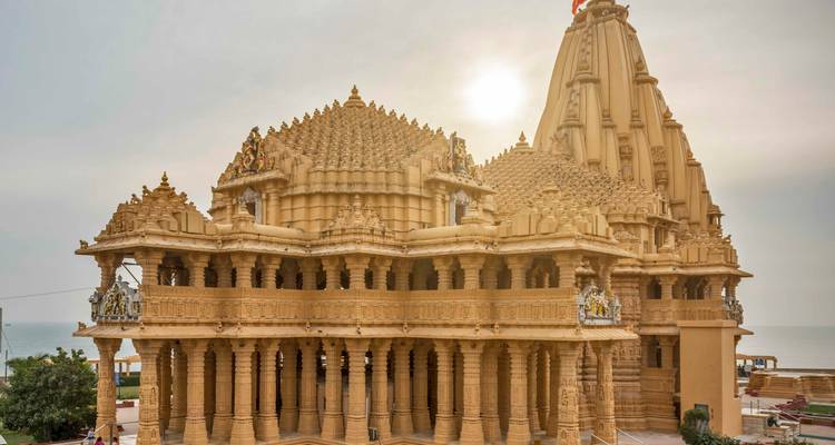 The golden sandstone Somnath Temple glowing in backlight near the Arabian Sea.