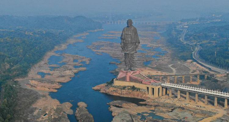 Aerial view of the colossal Statue of Unity towering over the Narmada River valley.
