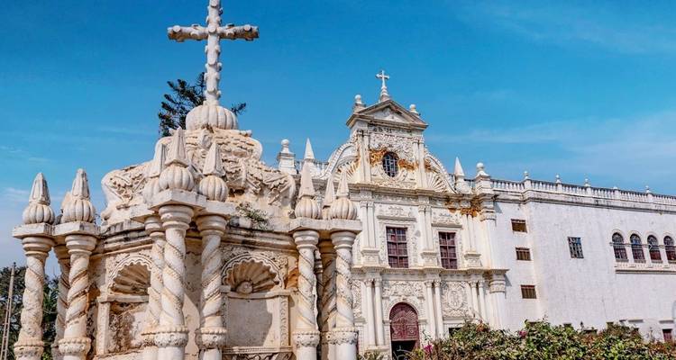 Another angle of Diu's ornate white St. Paul's Church against a vibrant blue sky.