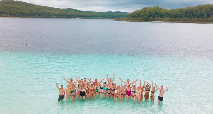 Un grand groupe touristique debout dans les eaux cristallines du lac McKenzie sur l'île Fraser.