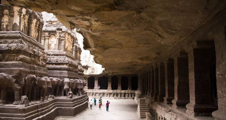 Les visiteurs parcourent les piliers bordés d'éléphants du majestueux temple de Kailasa taillé dans le roc massif.