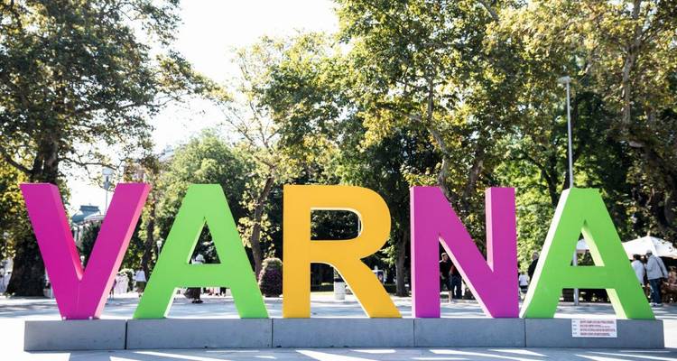 Panneau VARNA multicolore éclatant situé parmi des arbres feuillus par une journée ensoleillée