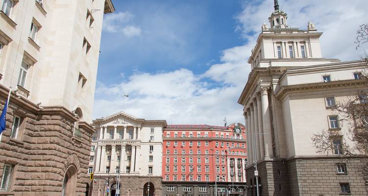 Place ouverte flanquée de bâtiments gouvernementaux bulgares sous un ciel bleu éclatant