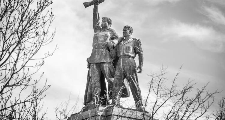 Image en noir et blanc d'un monument aux héros de l'époque soviétique avec un ciel nuageux en arrière-plan