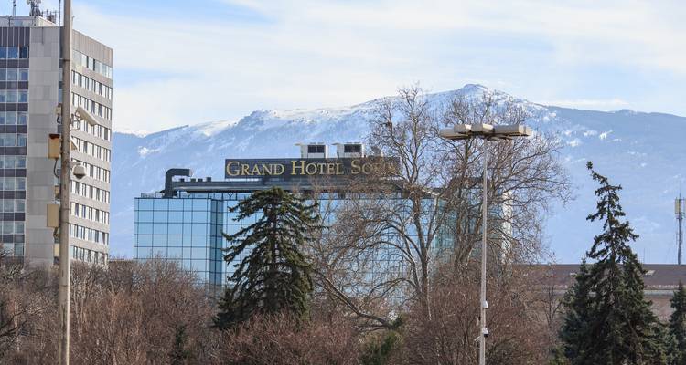 Grand Hotel Sofia à façade vitrée avec des montagnes enneigées à distance